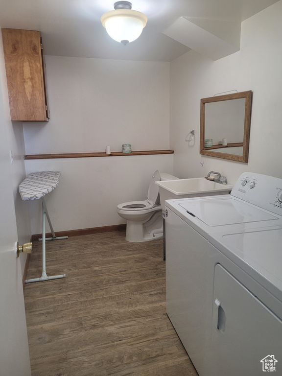 Laundry area featuring washing machine and clothes dryer, wood finished floors, and baseboards
