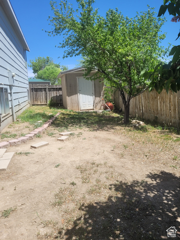 Fenced backyard with a storage unit and an outdoor structure