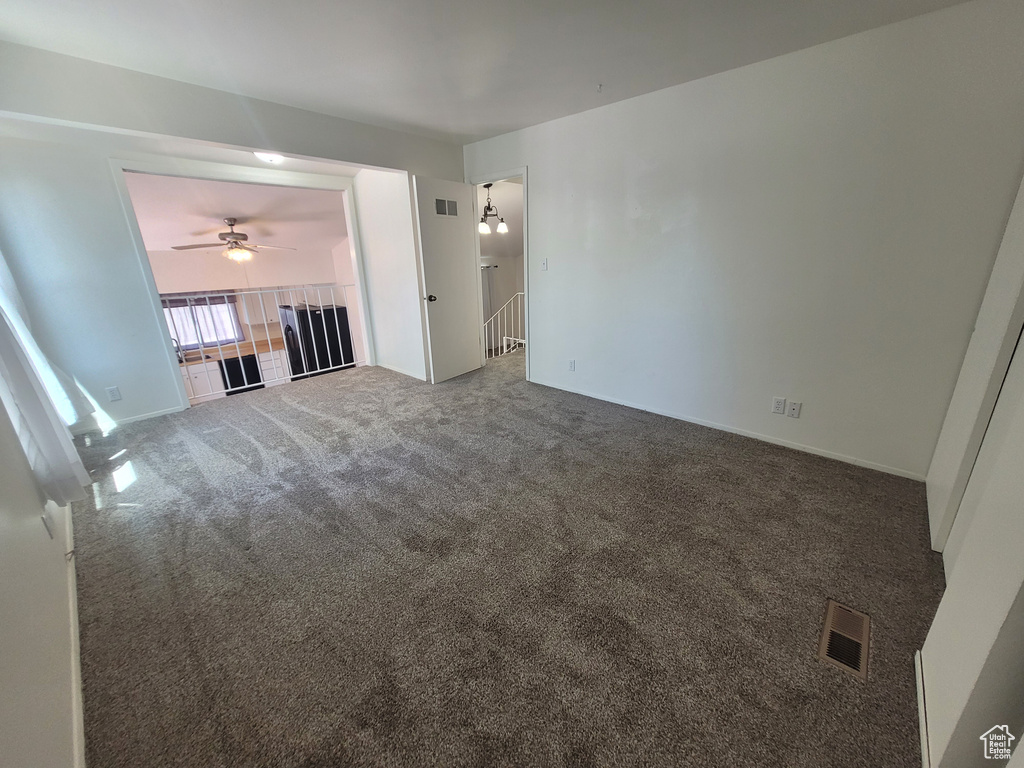 Unfurnished living room with carpet floors and ceiling fan