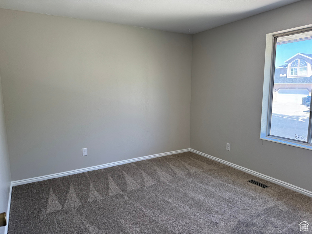 Unfurnished room featuring carpet and baseboards