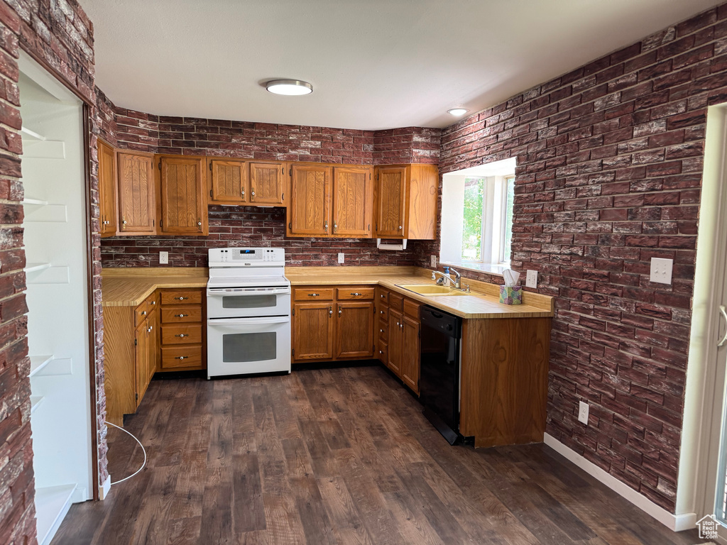 Kitchen featuring range with two ovens, a sink, dishwasher, brown cabinets, and light countertops