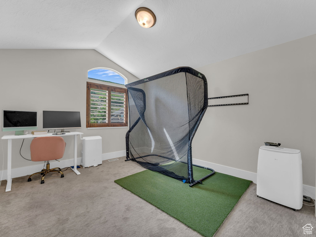 Carpeted home office featuring lofted ceiling and baseboards