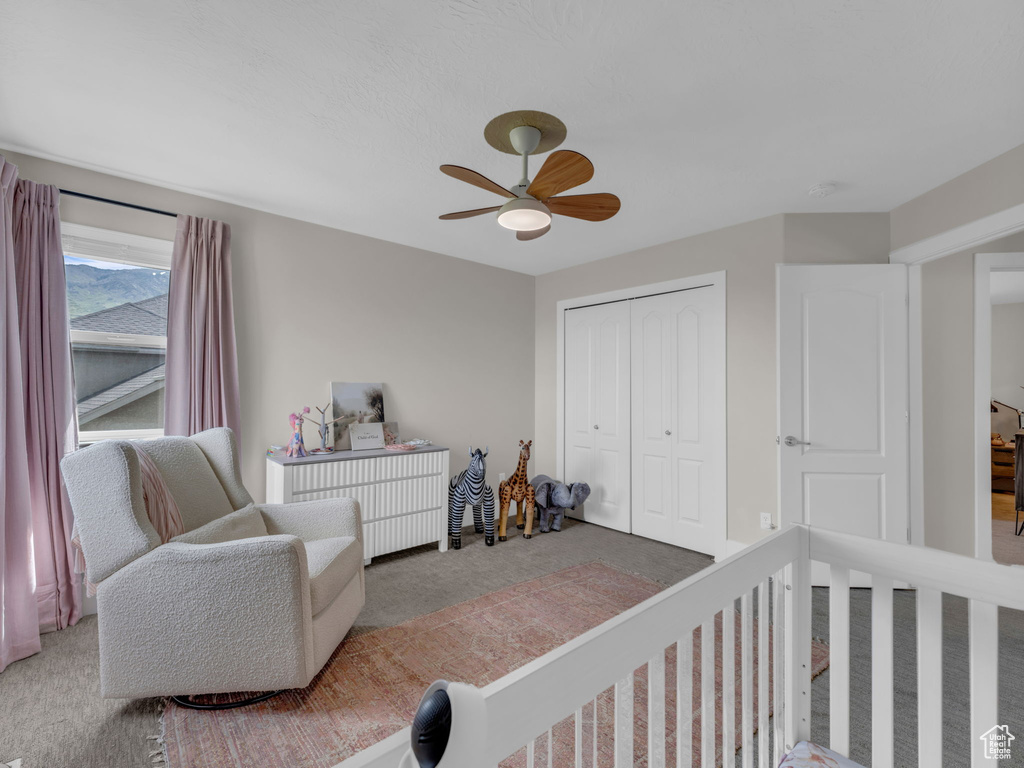 Carpeted bedroom featuring a closet and a ceiling fan