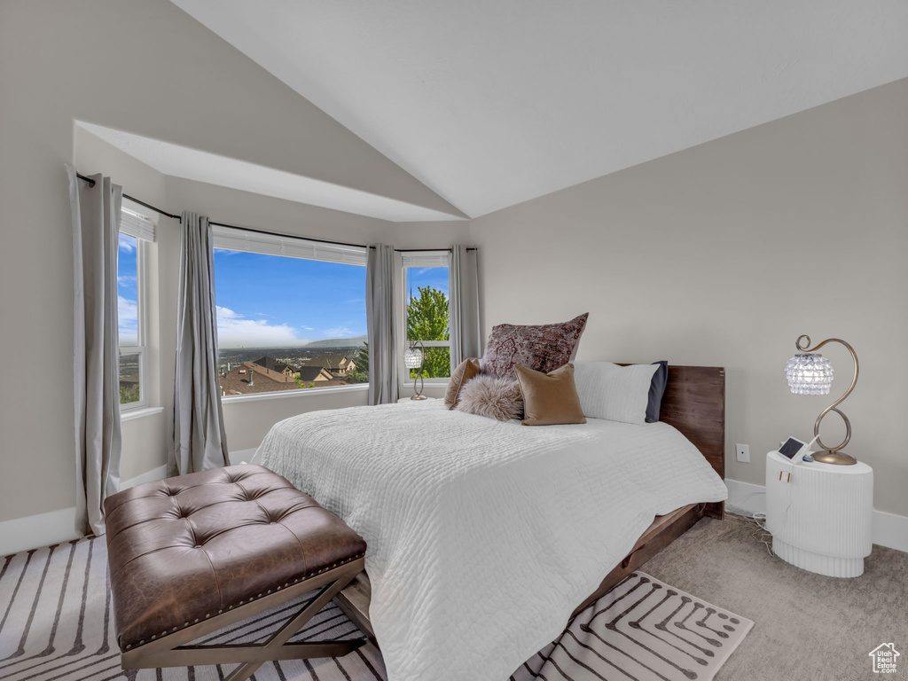 Bedroom featuring vaulted ceiling, carpet flooring, and baseboards