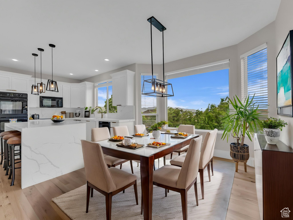 Dining area with light wood-style flooring, a chandelier, and recessed lighting