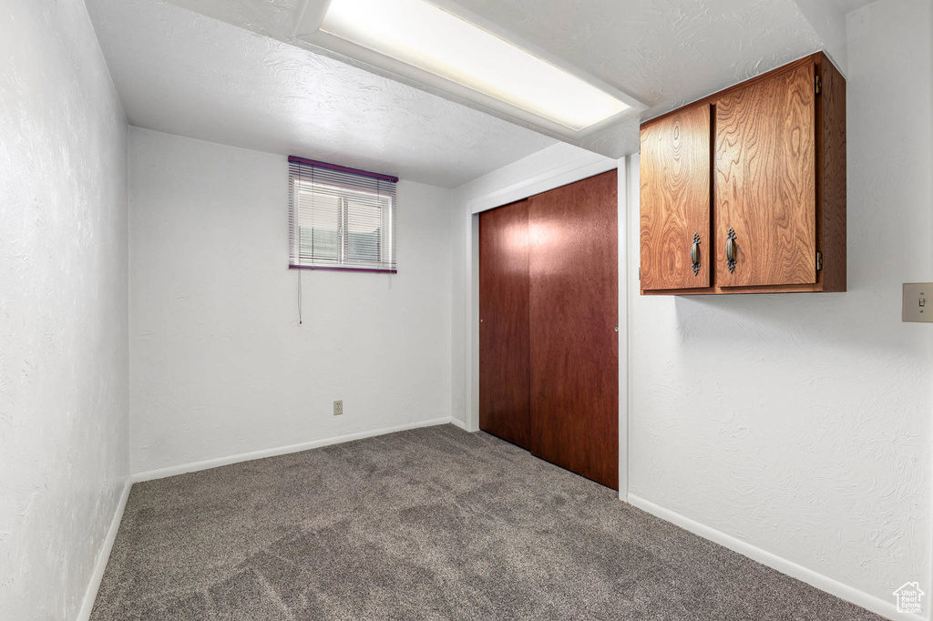 Carpeted empty room with baseboards