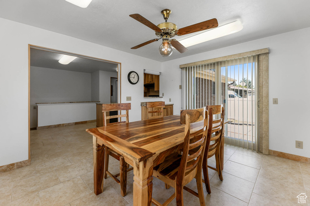 Dining room with baseboards, ceiling fan, and light tile patterned flooring