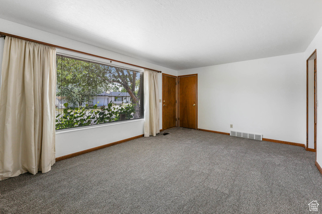 Unfurnished bedroom with light carpet and baseboards