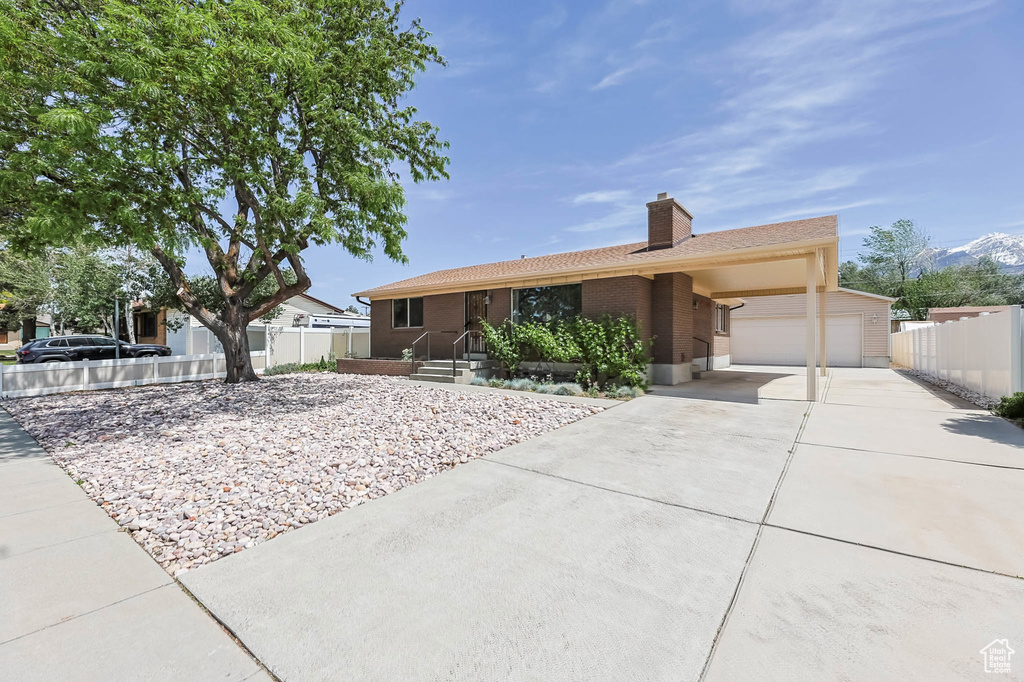 Single story home featuring a garage, driveway, fence, and brick siding