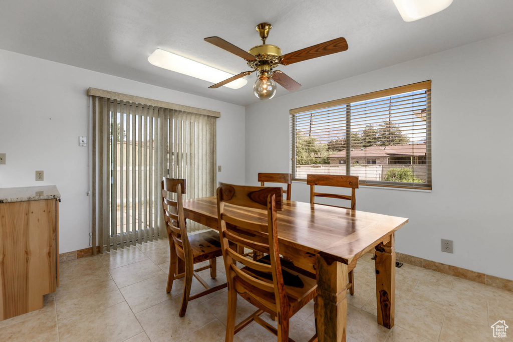 Dining space with baseboards, light tile patterned flooring, and a ceiling fan