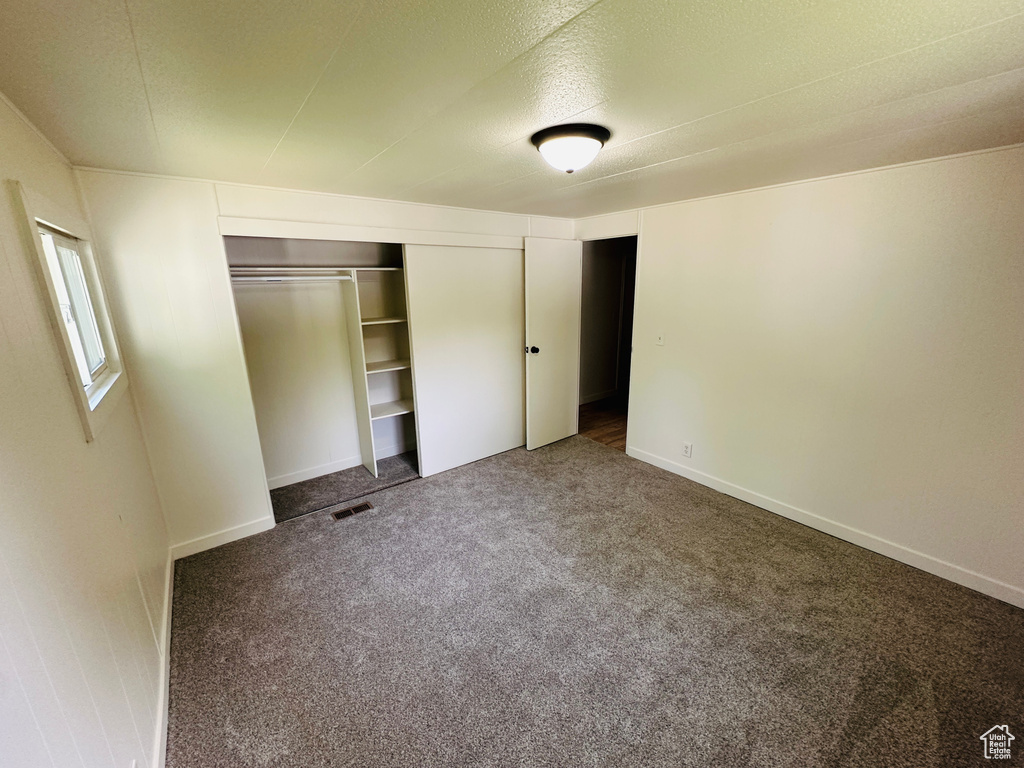 Unfurnished bedroom featuring carpet floors, a closet, and baseboards