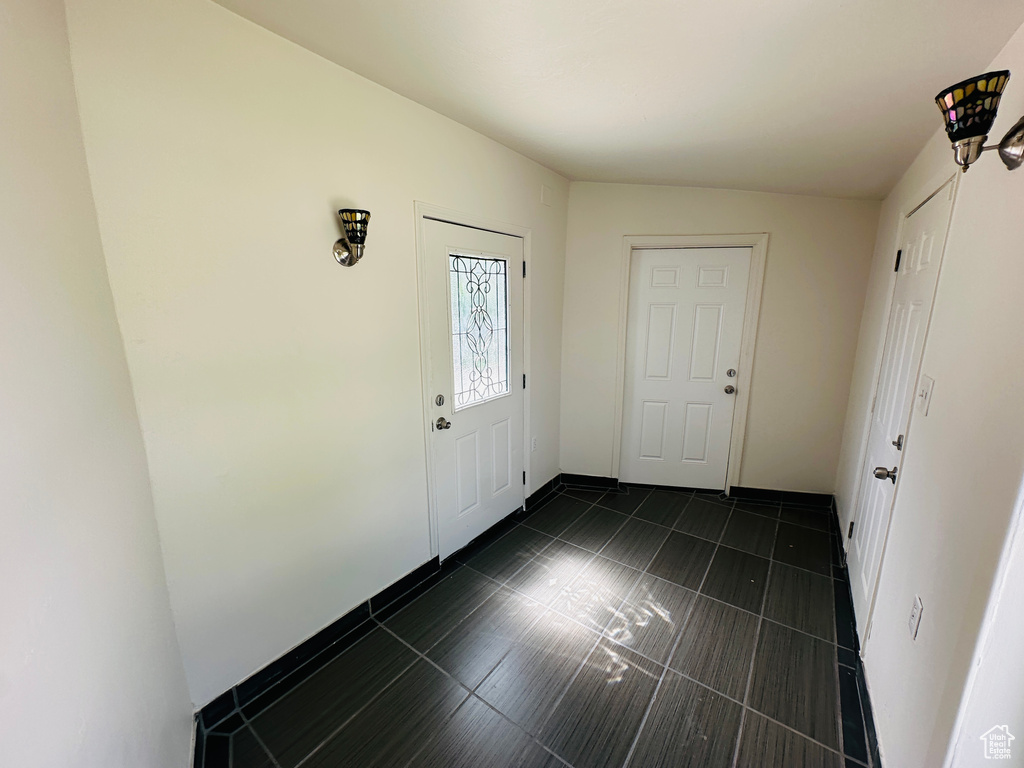 Entrance foyer featuring dark tile patterned floors and baseboards