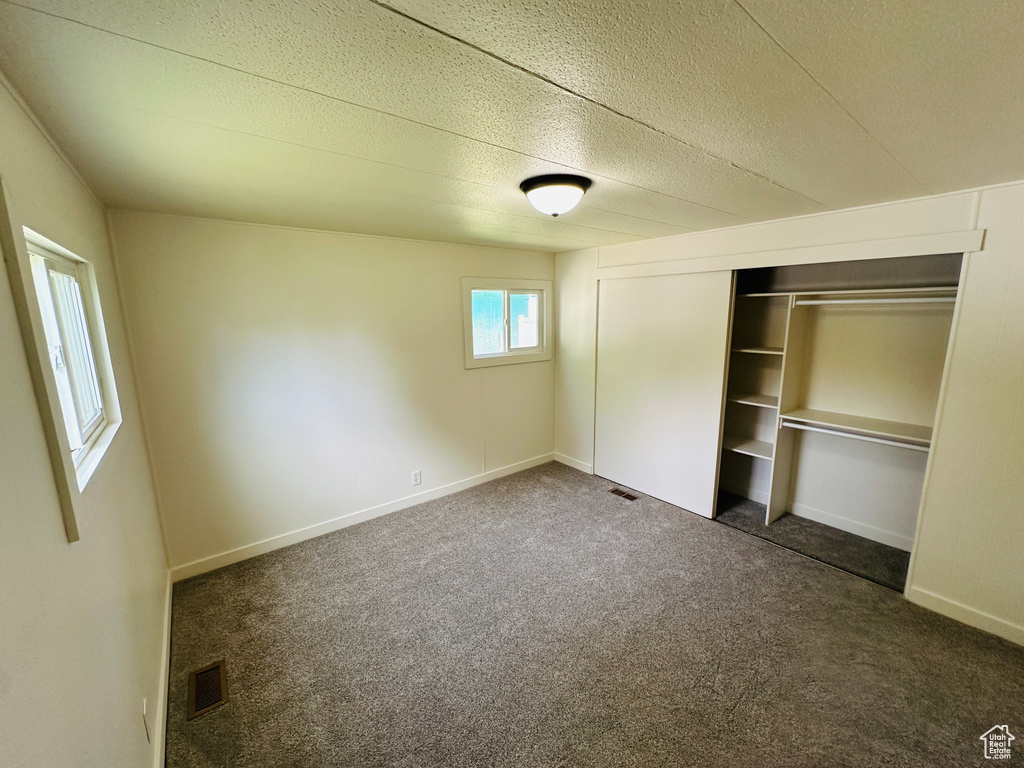 Unfurnished bedroom featuring carpet flooring, a closet, and baseboards
