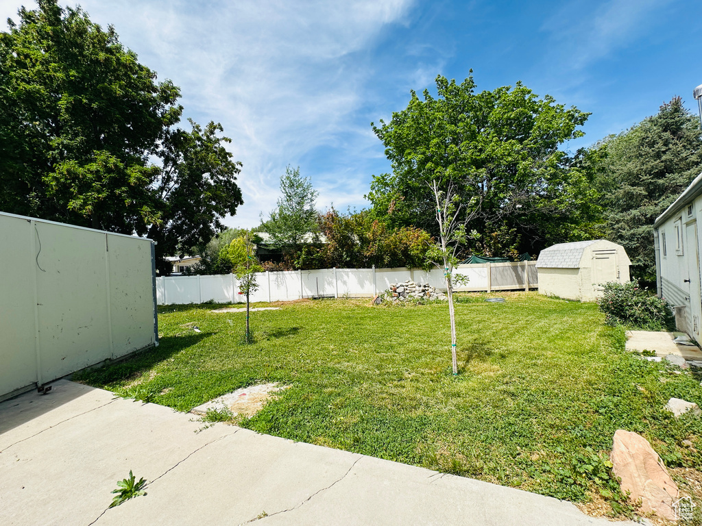 View of yard with a storage shed and an outdoor structure