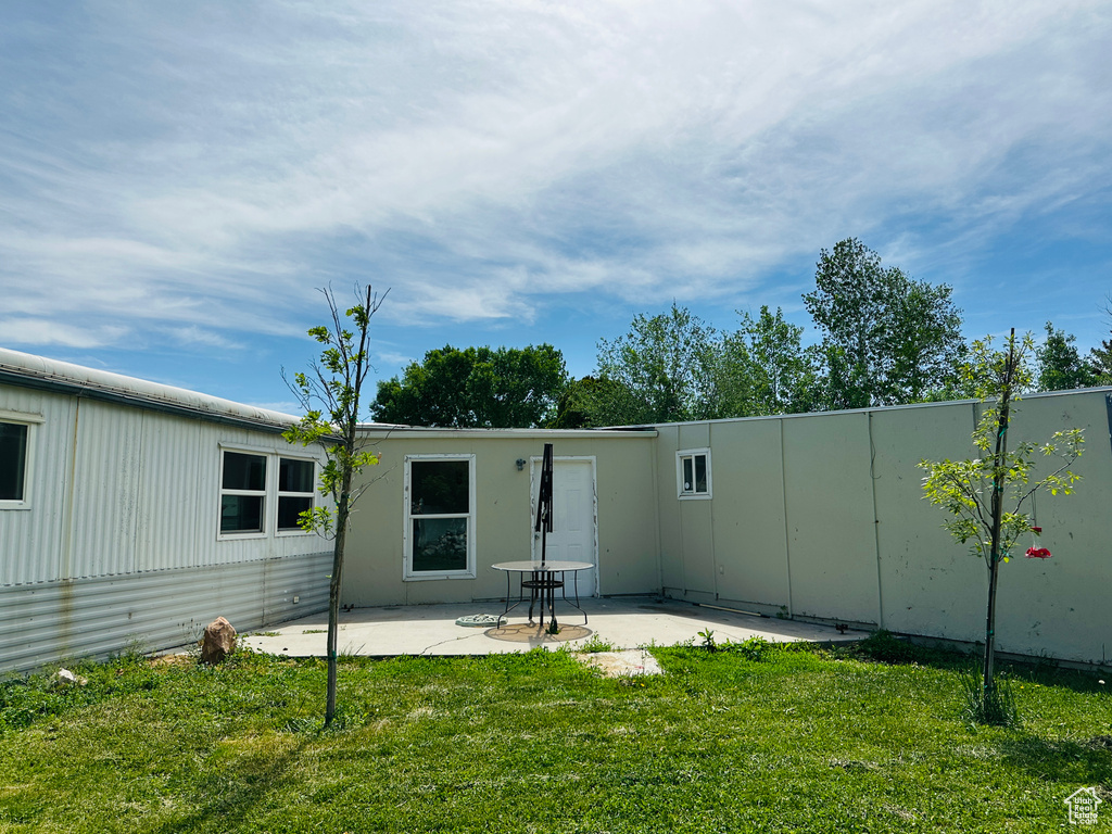 Rear view of house with a patio and a yard