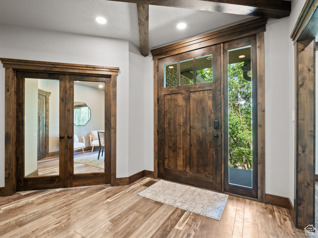 Entrance foyer featuring baseboards, french doors, light wood-style floors, and recessed lighting