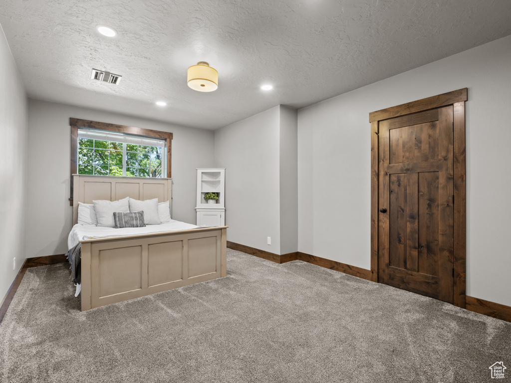 Bedroom featuring baseboards, carpet flooring, a textured ceiling, and recessed lighting
