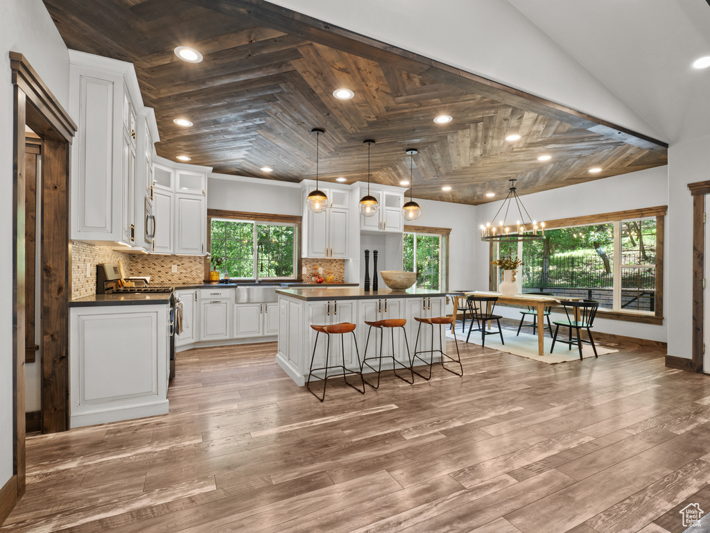 Kitchen featuring gas stove, dark countertops, tasteful backsplash, white cabinets, and recessed lighting