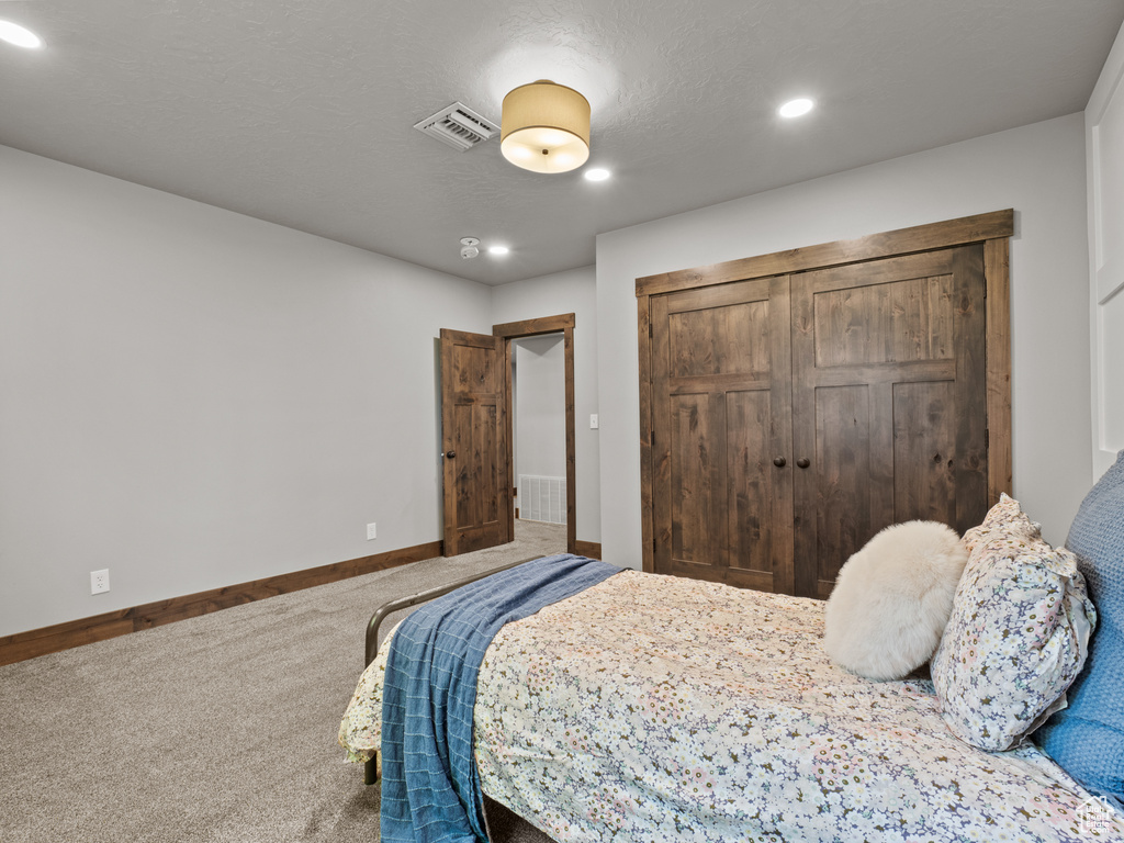 Bedroom featuring carpet flooring, a closet, baseboards, and recessed lighting