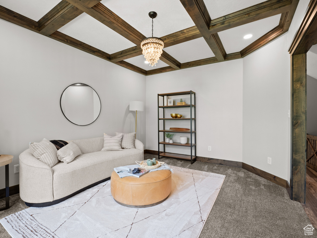 Living room with coffered ceiling, a chandelier, light carpet, beam ceiling, and baseboards