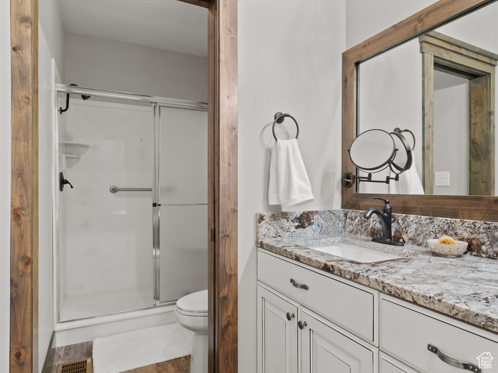 Full bath with a stall shower, toilet, and vanity