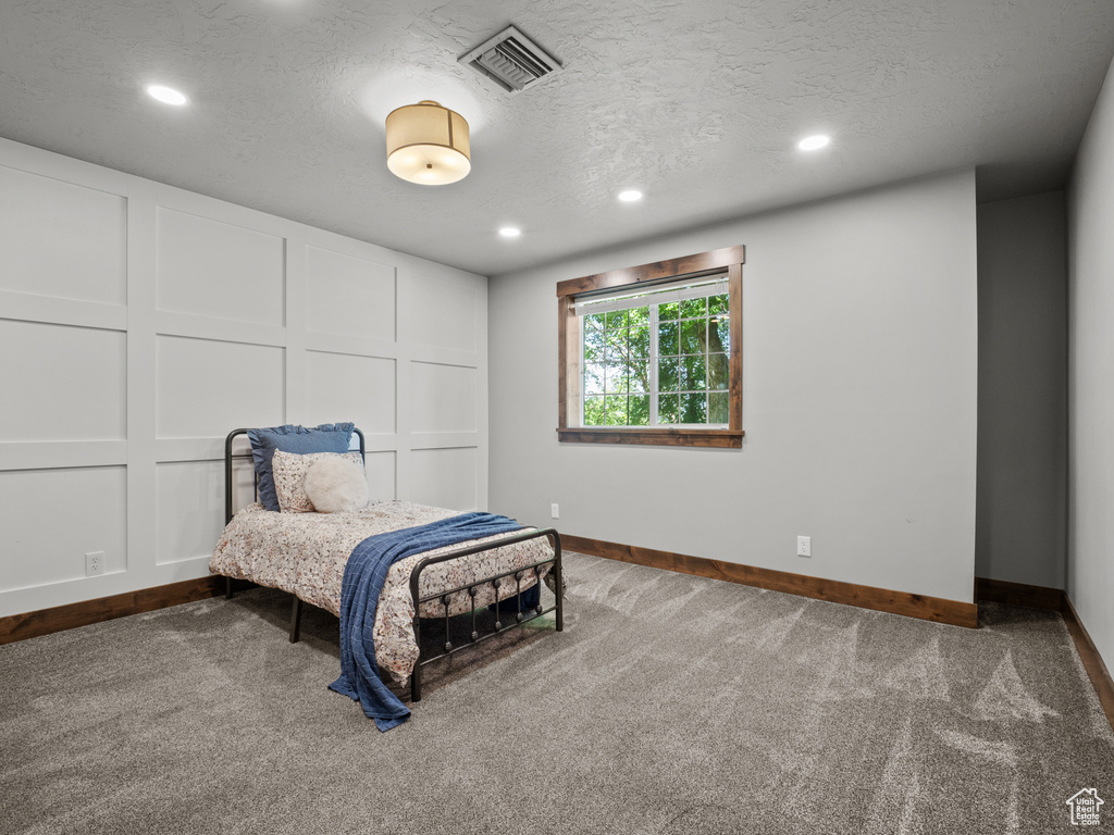 Carpeted bedroom featuring baseboards, recessed lighting, and a textured ceiling