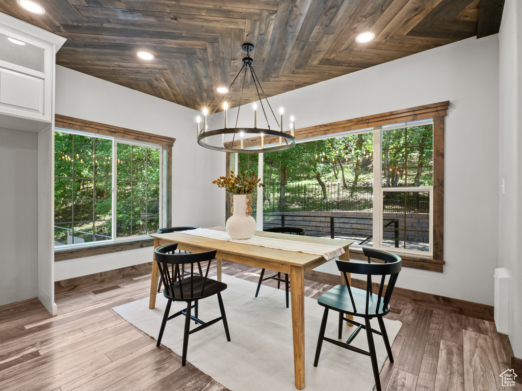 Dining room with a chandelier, baseboards, light wood-style floors, recessed lighting, and wooden ceiling
