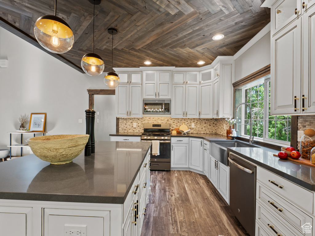 Kitchen with stainless steel appliances, dark countertops, wood ceiling, a sink, and recessed lighting