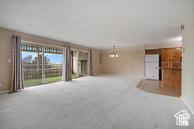Unfurnished living room with baseboards and light colored carpet