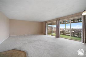 Unfurnished living room with carpet floors and baseboards