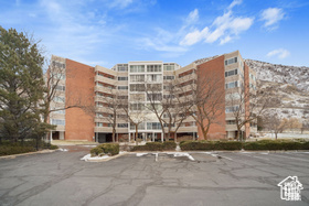 View of apartment building / complex featuring uncovered parking