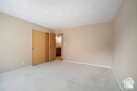 Carpeted empty room with baseboards