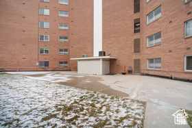 Snow covered building featuring a view of apartment building / complex