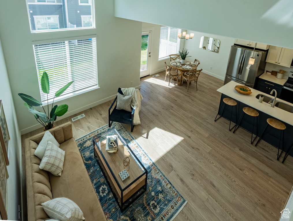 Living room featuring baseboards, a chandelier, and light wood-style flooring