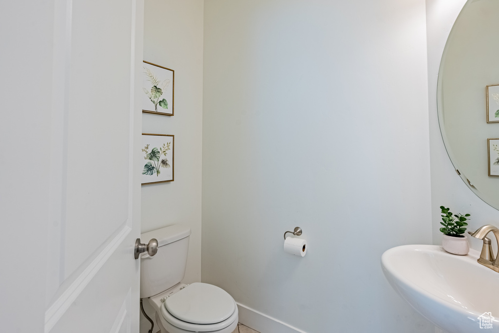 Bathroom with a sink, toilet, and baseboards