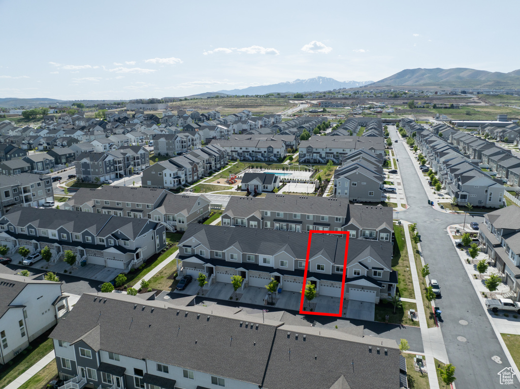 Aerial perspective of suburban area with property parcel outlined and a mountainous background