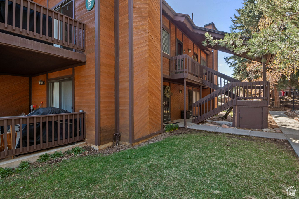 View of side of property with a lawn and stairs