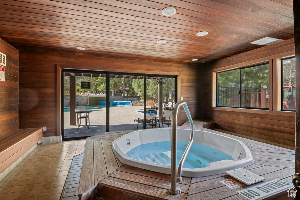Wooden terrace with an in-ground hot tub and a patio area