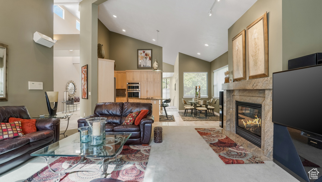 Living room featuring high vaulted ceiling, a fireplace, and recessed lighting