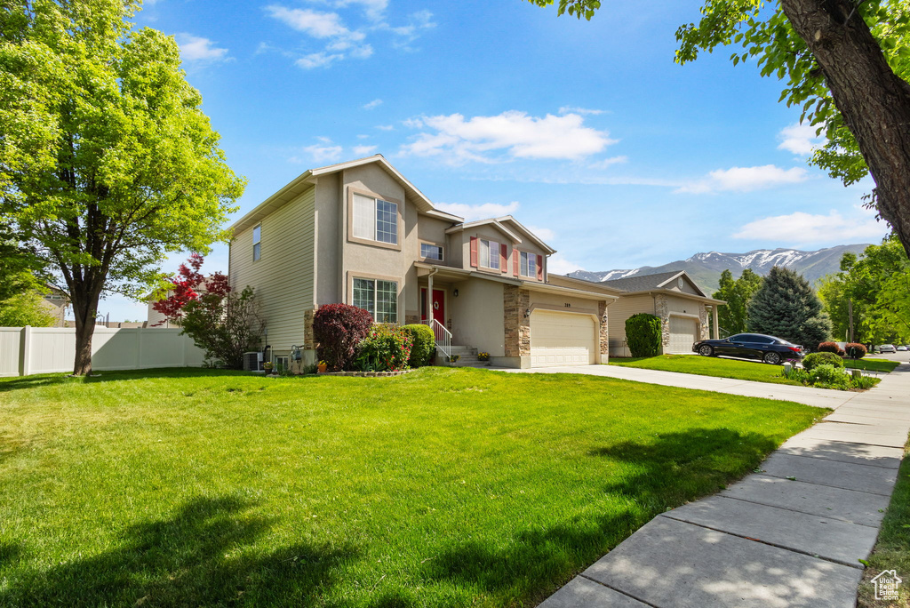 Traditional-style home featuring driveway, stucco siding, stone siding, a mountain view, and central AC