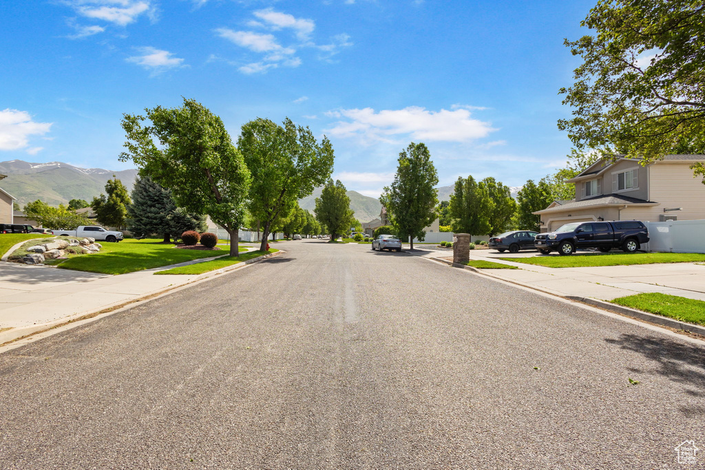 View of asphalt street featuring a mountain view and curbs