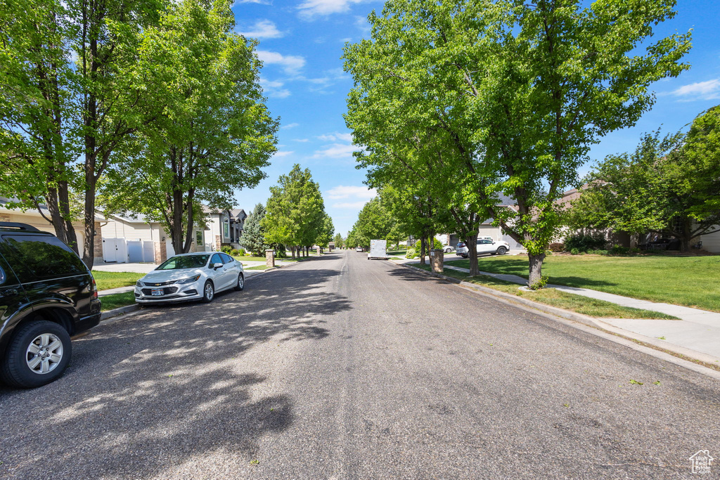 View of asphalt road featuring sidewalks, a residential view, and curbs