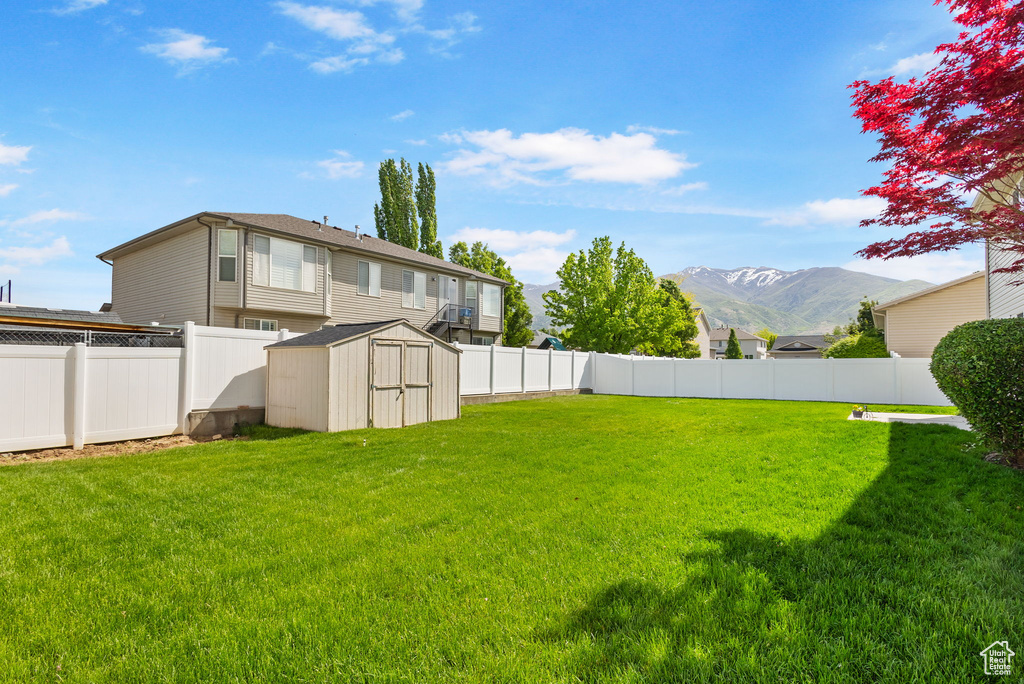 View of yard with a shed, an outbuilding, and a mountain view