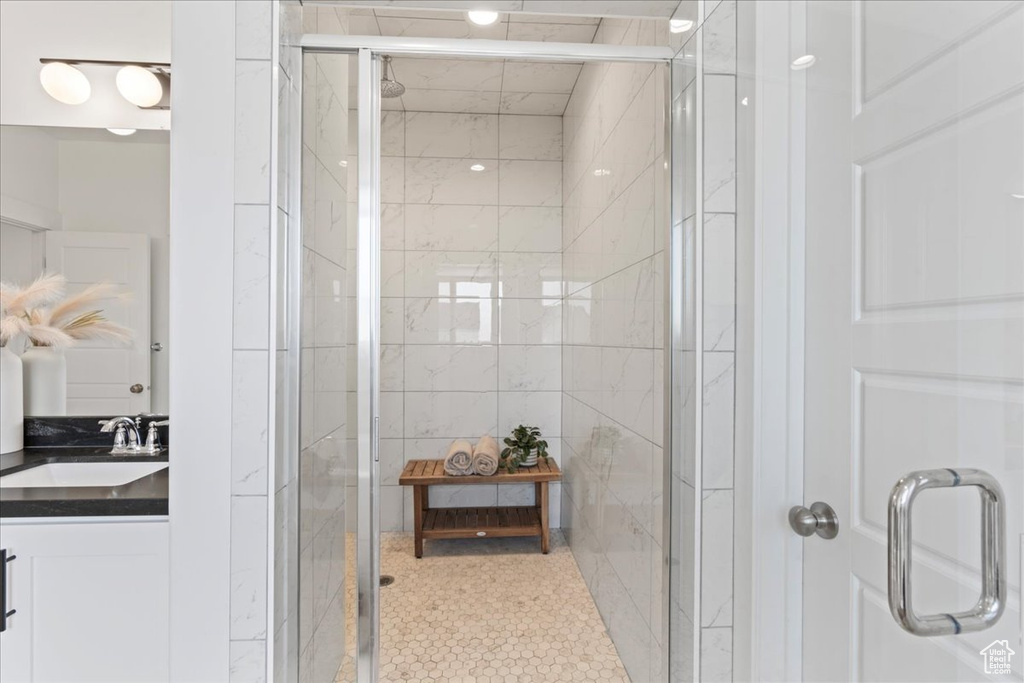 Full bath with a shower stall and vanity