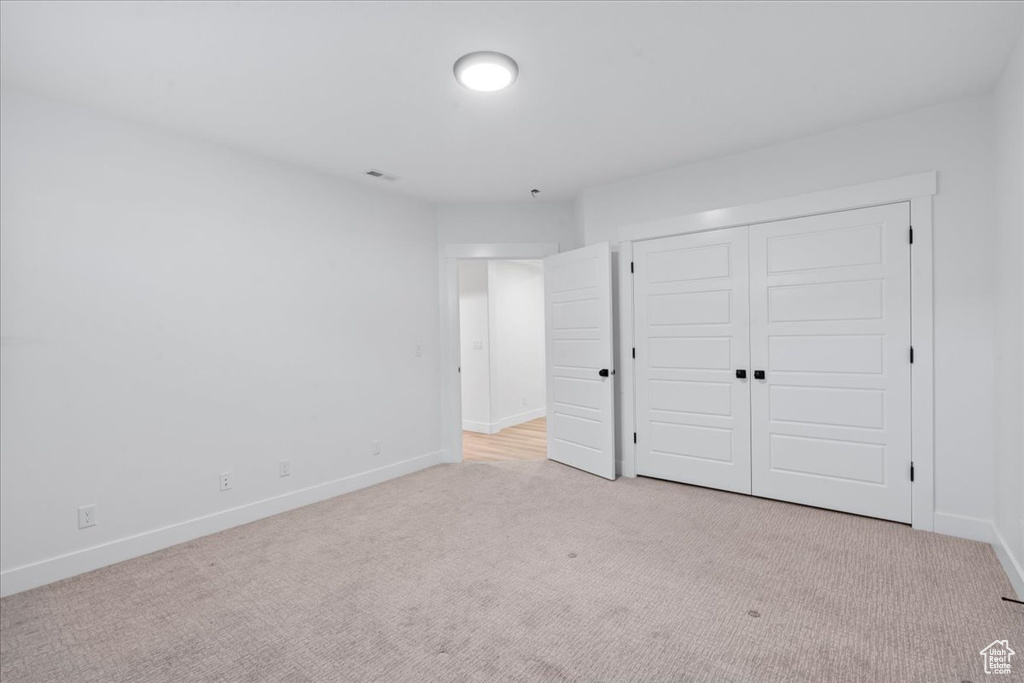 Unfurnished bedroom with carpet flooring, baseboards, and a closet