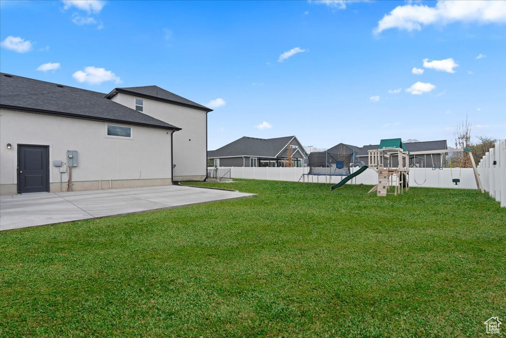 View of yard featuring a playground, a patio area, and a residential view