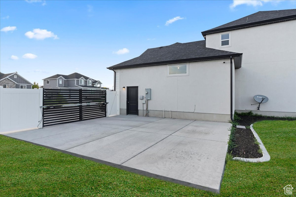 Back of house featuring a gate and stucco siding