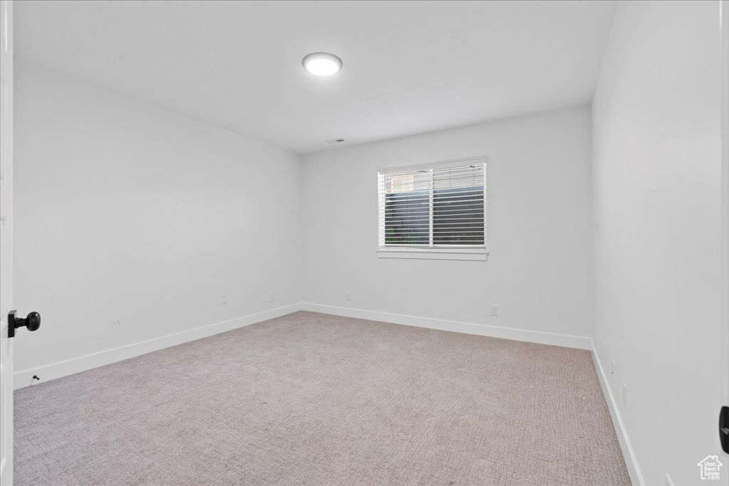Unfurnished room with light colored carpet and baseboards