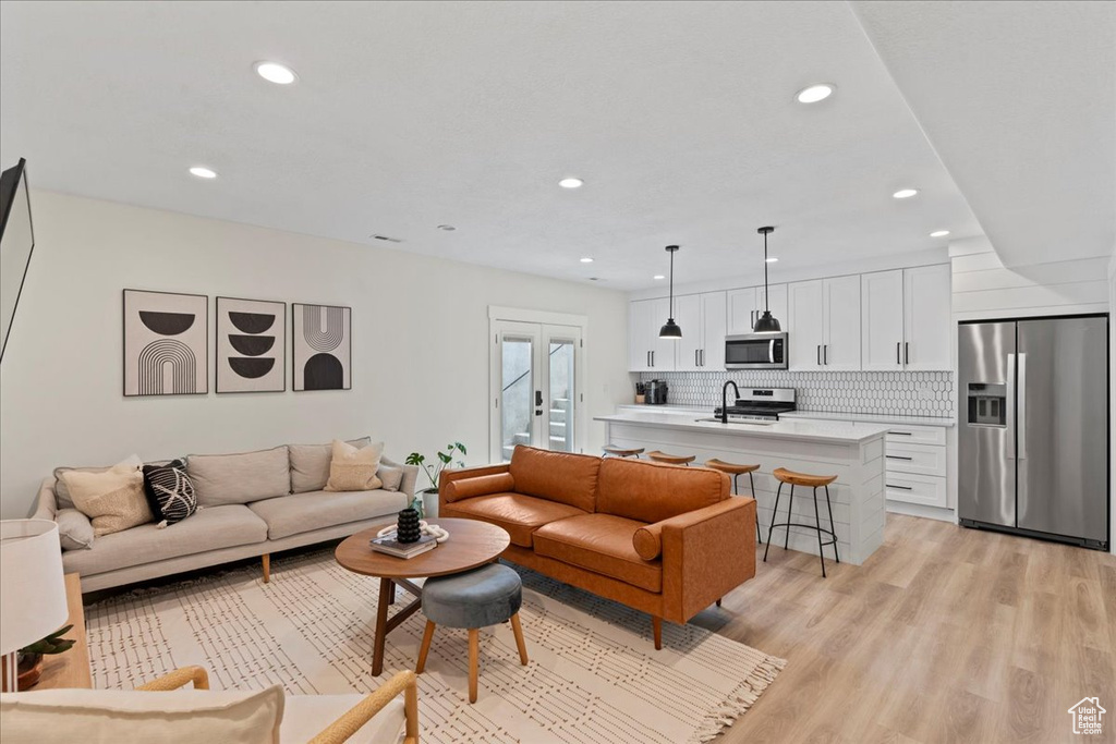 Living area featuring recessed lighting, light wood finished floors, and french doors