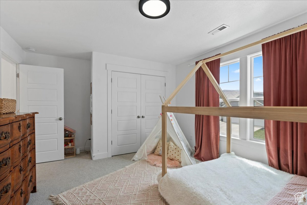Bedroom featuring carpet and a closet